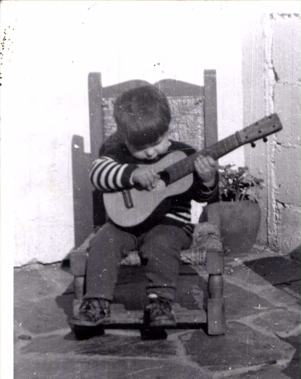 Ariel Ameijenda de niño, con una guitarra en la falda